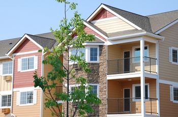 Apartments with patios and balconies and a tree in front. at Quail Springs, West Richland, WA, 99353